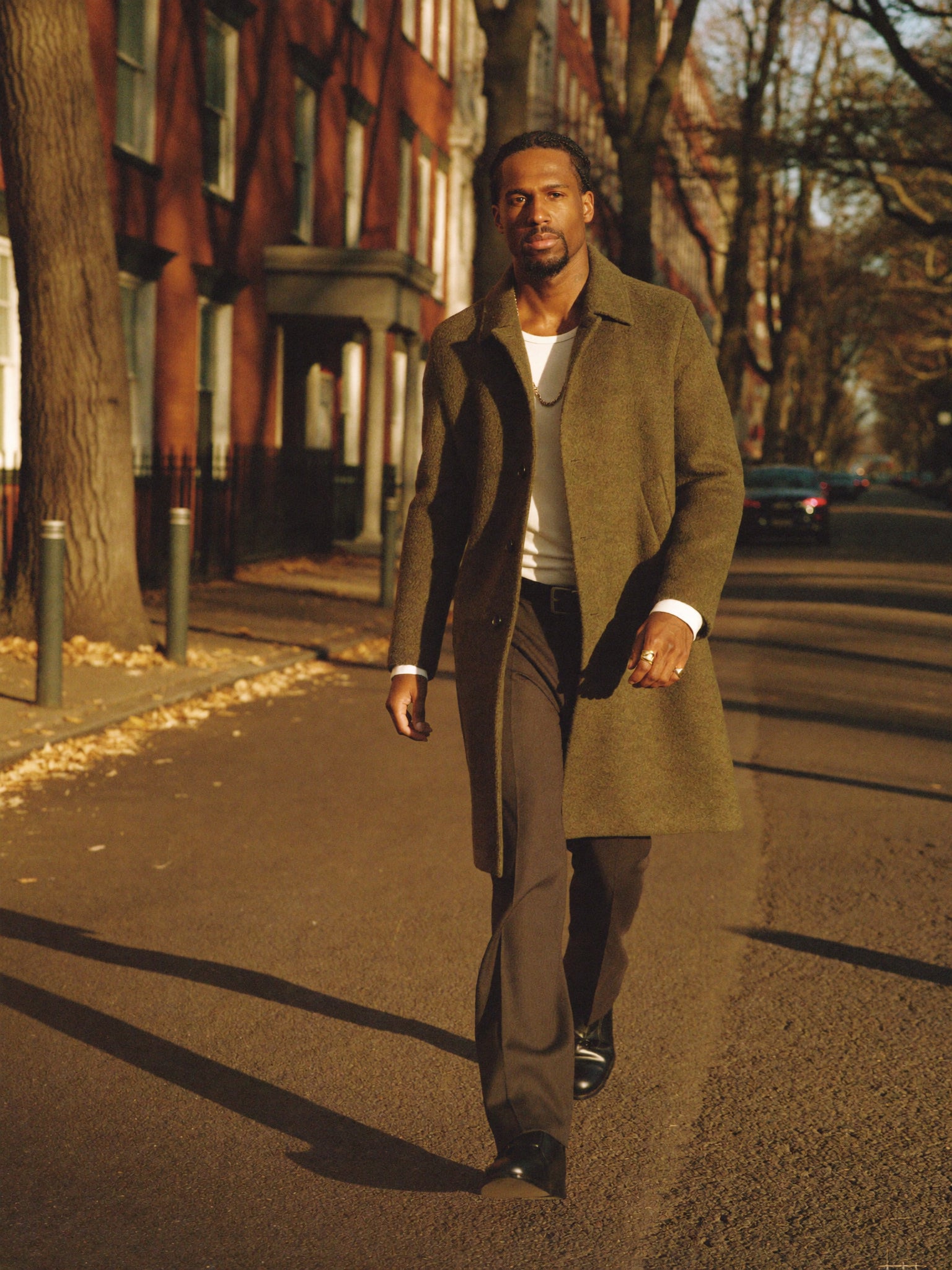A man in a dark wool coat walking on an autumn London street